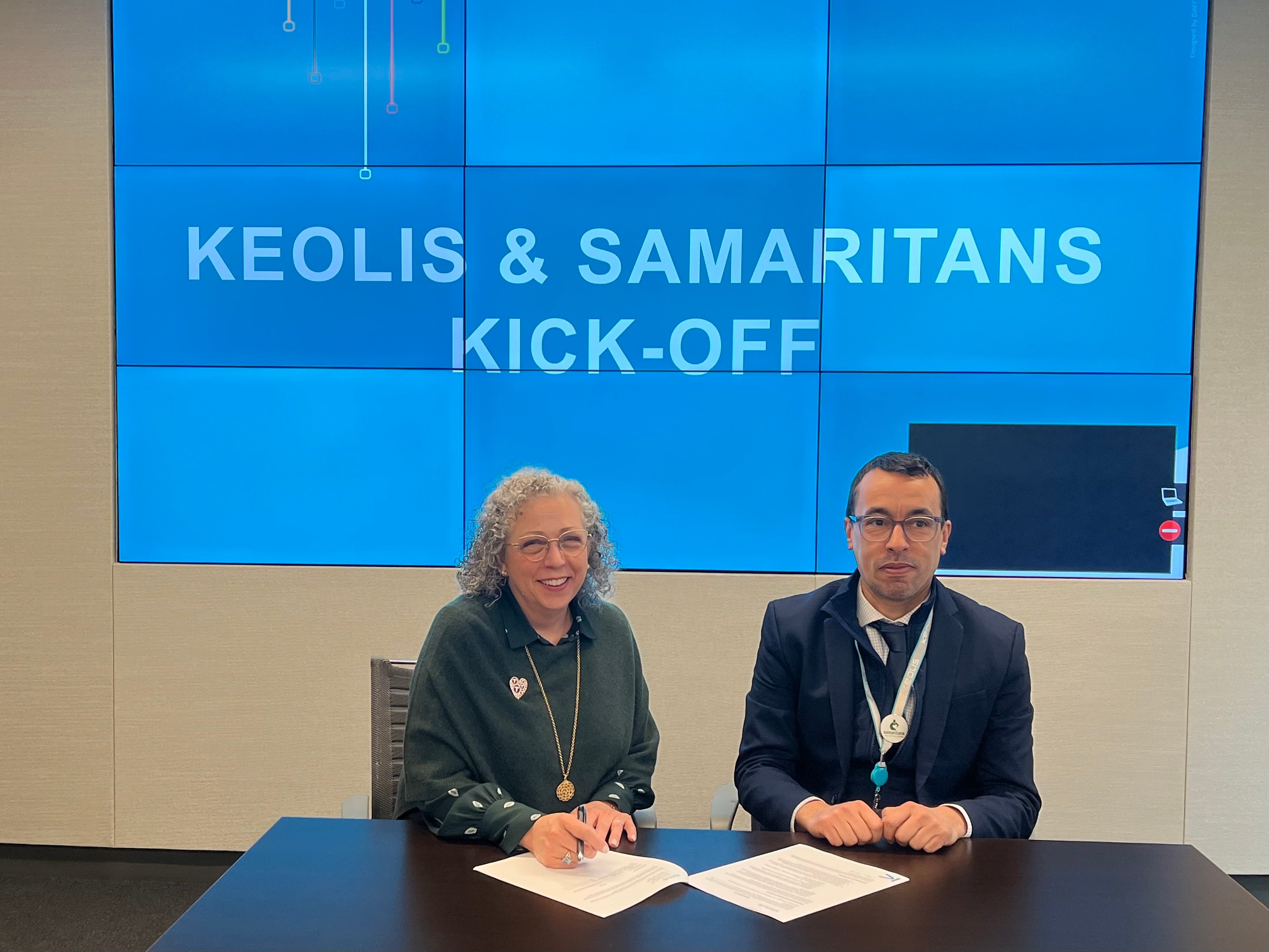 Samaritans CEO Kathy Marchi and Keolis Commuter Services CEO Abdellah Chajai sit down to sign service agreement for expanded partnership.